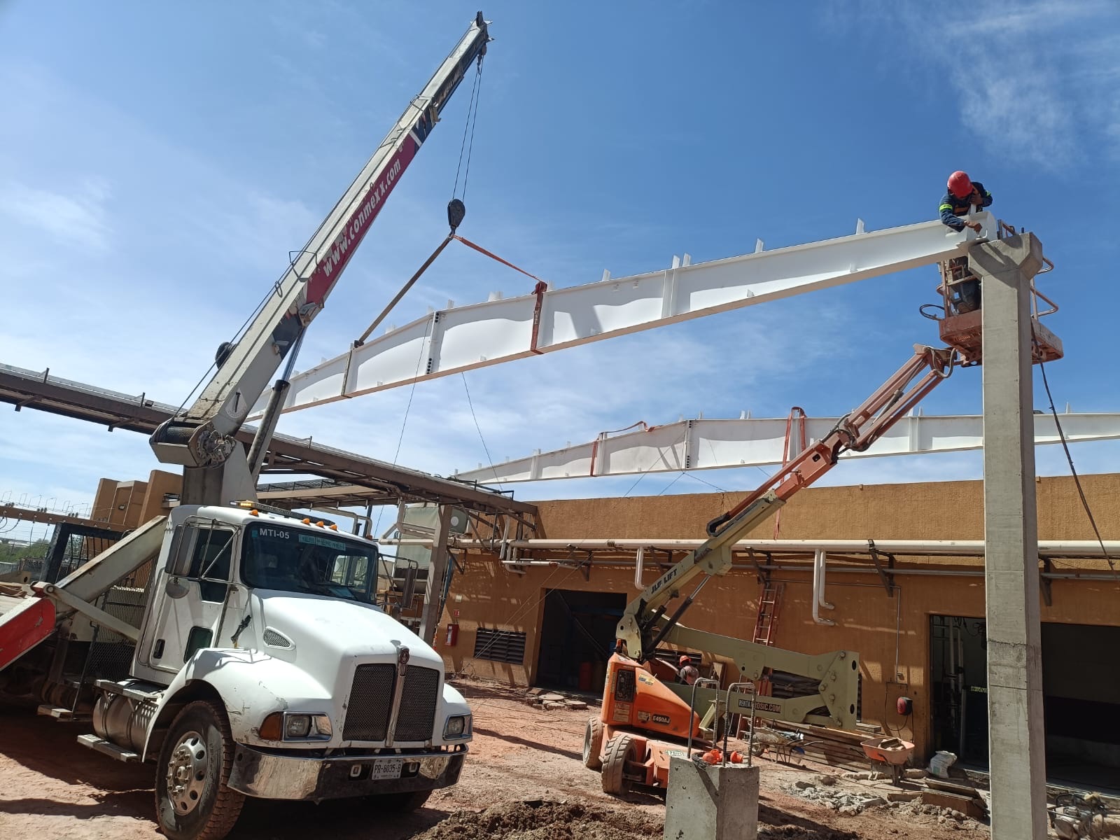 Obra exterior e infraestructura con grúa, camión y montaje en campo