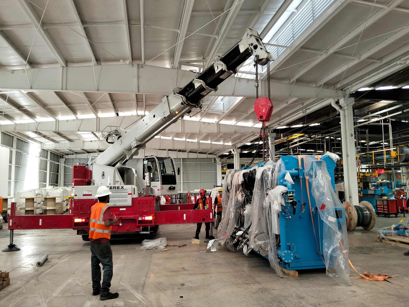 Maniobra industrial dentro de nave con grúa y equipo especializado